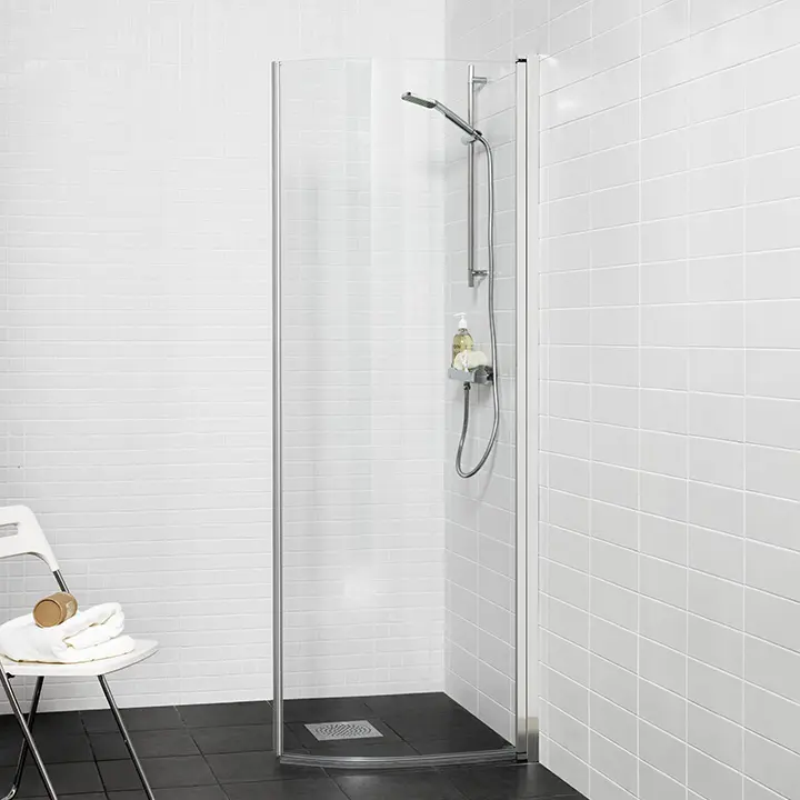 Moderne og let buet brusedør med elegante kromfarvede profiler.